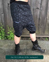 Organic cotton drop crotch shorts, black with geometric fabric print, front right side view on model.