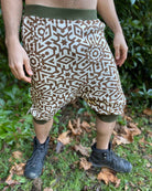 Organic cotton drop crotch shorts, undyed fabric with geometric print, front view on male model.