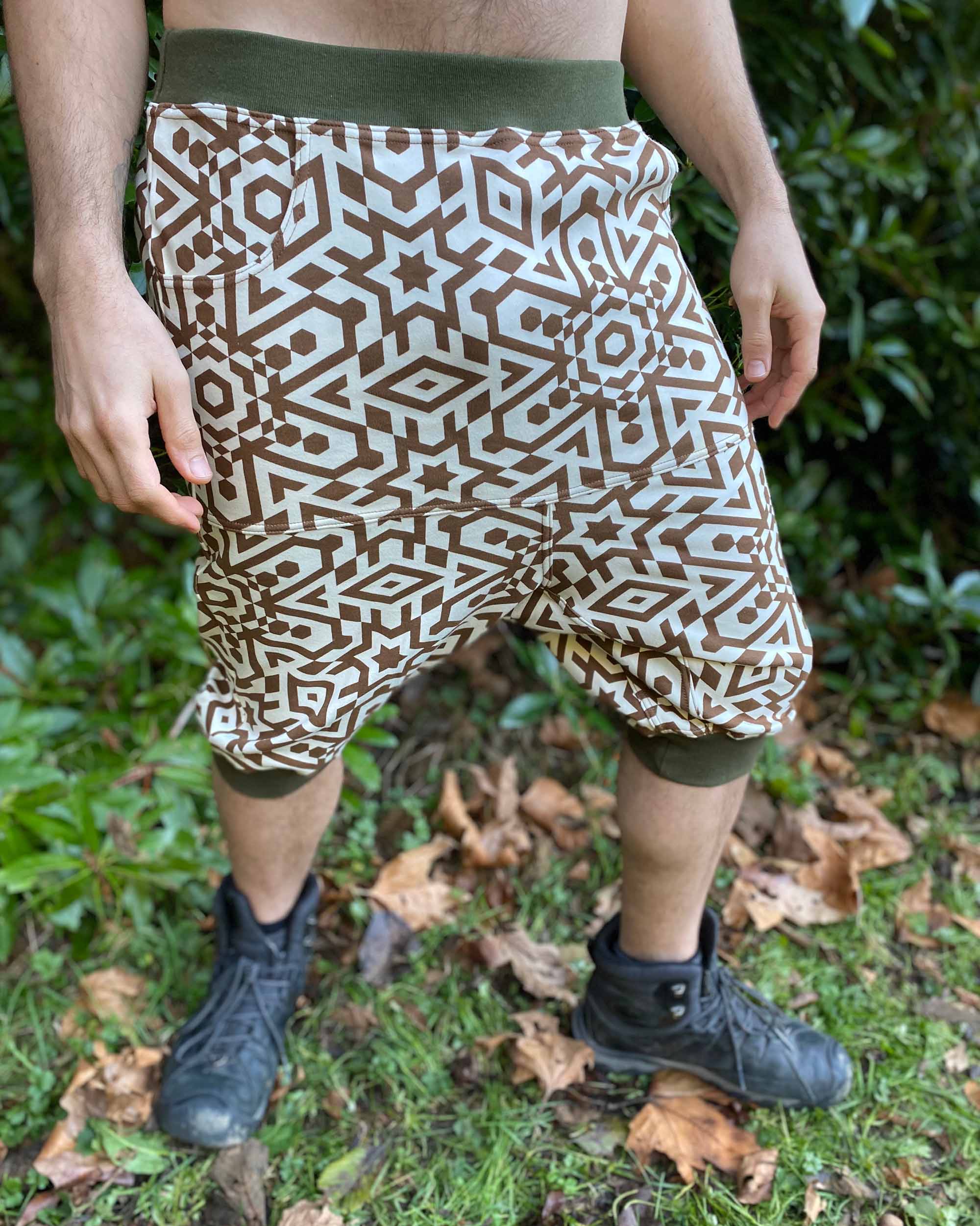 Organic cotton drop crotch shorts, undyed fabric with geometric print, front view on male model.