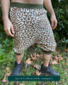 Organic cotton drop crotch shorts, undyed fabric with brown geometric print, front right side view on male model.