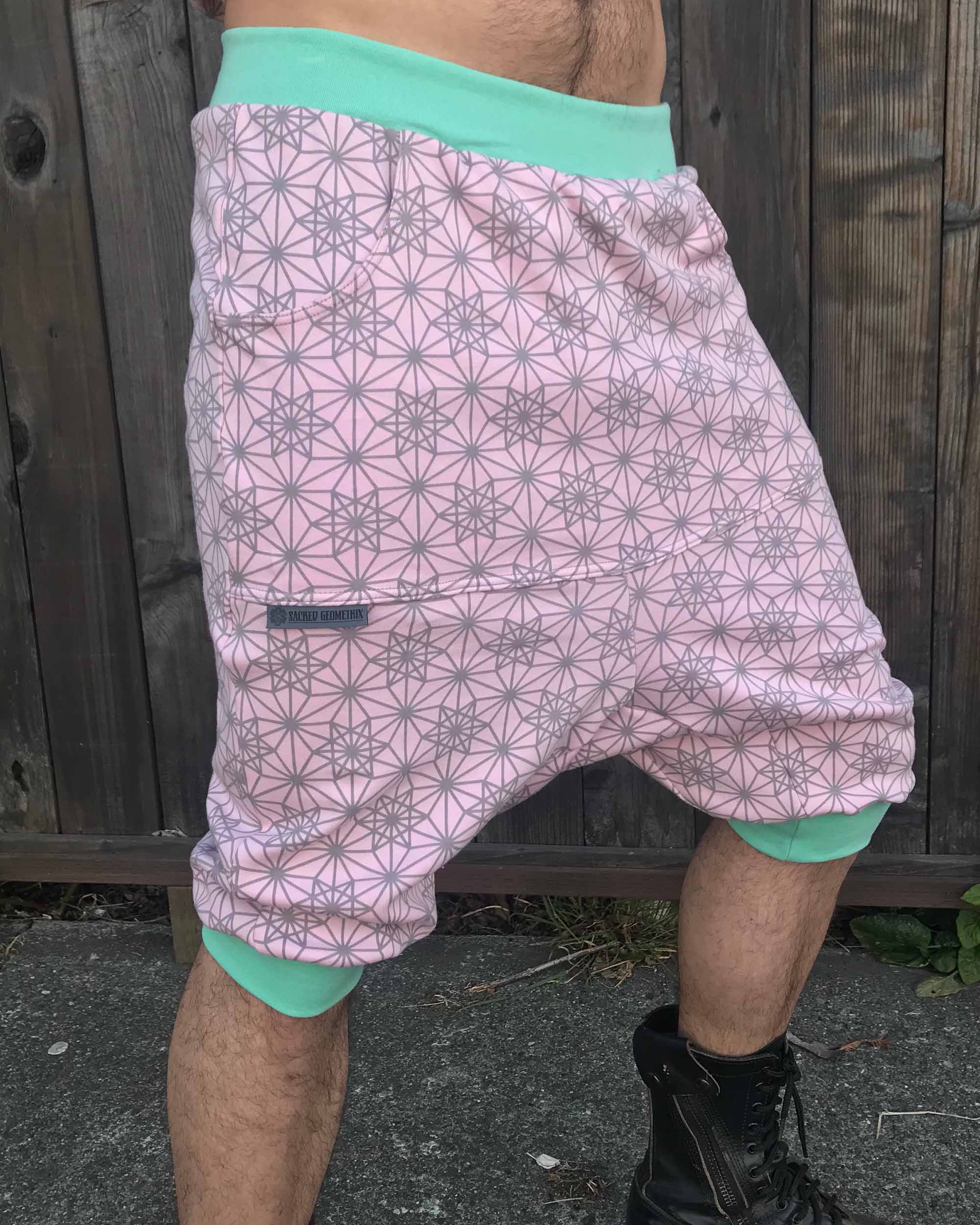 Organic cotton drop crotch shorts, pink with geometric fabric print, front right side view on model.