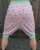 Organic cotton drop crotch shorts, pink with geometric fabric print, back view on model.