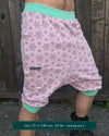 Organic cotton drop crotch shorts, pink with sacred geometry print, right side view on model.