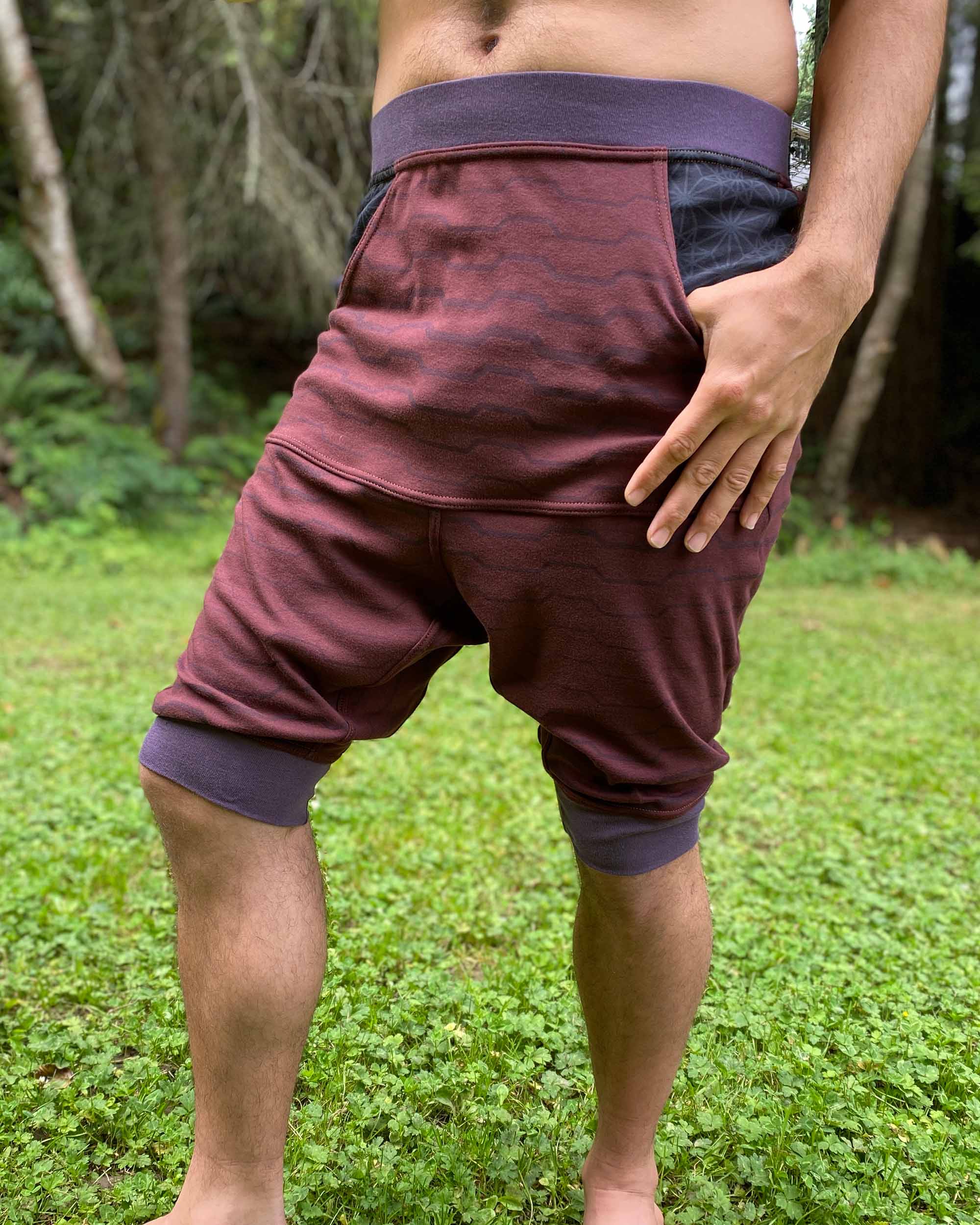Organic cotton drop crotch shorts, brown fabric with geometric print, front right view on model.  