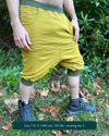 Organic cotton drop crotch shorts, yellow fabric with geometric stripes, right side view on model.