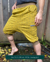 Organic cotton drop crotch shorts, yellow fabric with geometric print, front right side view on male model.