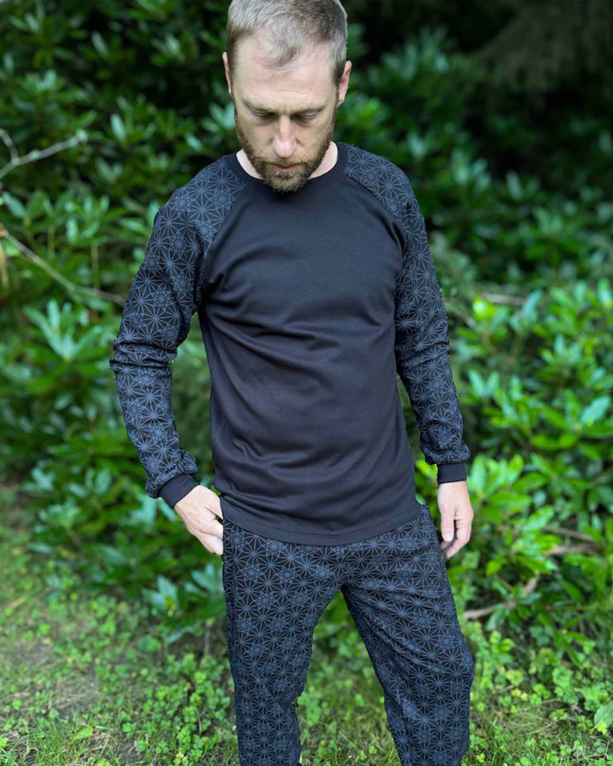 Organic cotton long sleeve shirt, black with vector equilibrium print, front view on male model.
