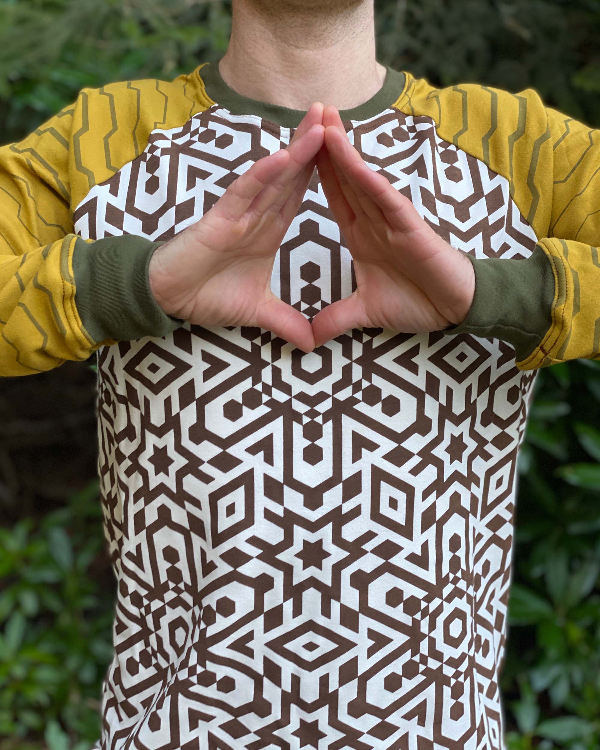 Organic cotton long sleeve shirt, undyed torso fabric with yellow geometric striped sleeves, front detail view of print.