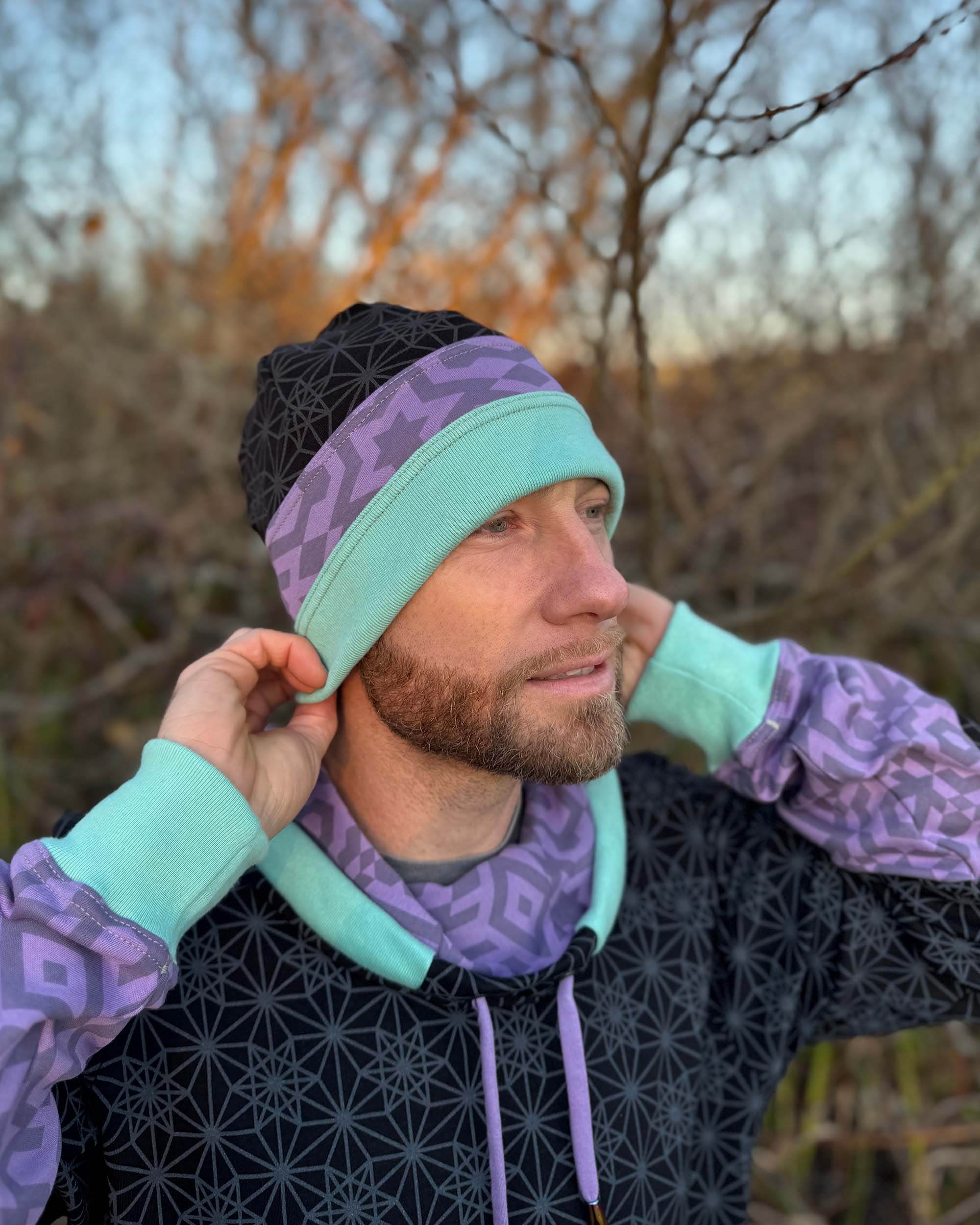 Organic cotton beanie, black, lavender and green accent fabric, front right view on male model.
