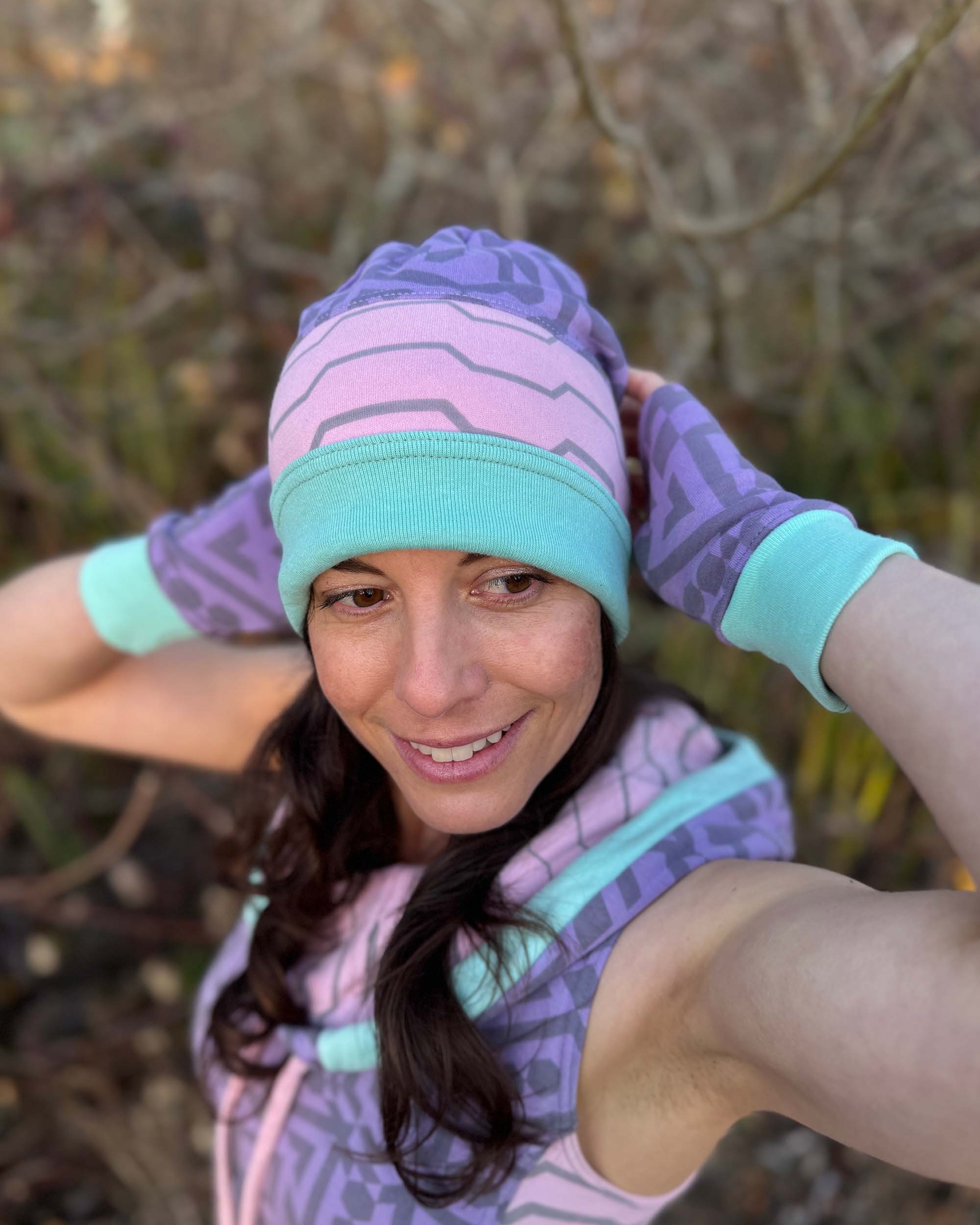 Organic cotton beanie, pink and lavender with geometric printed fabric, front side on female model.