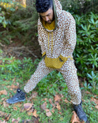 Men's matching two piece sweatsuit, brown geometric print organic fabric, front view, worn on male model.