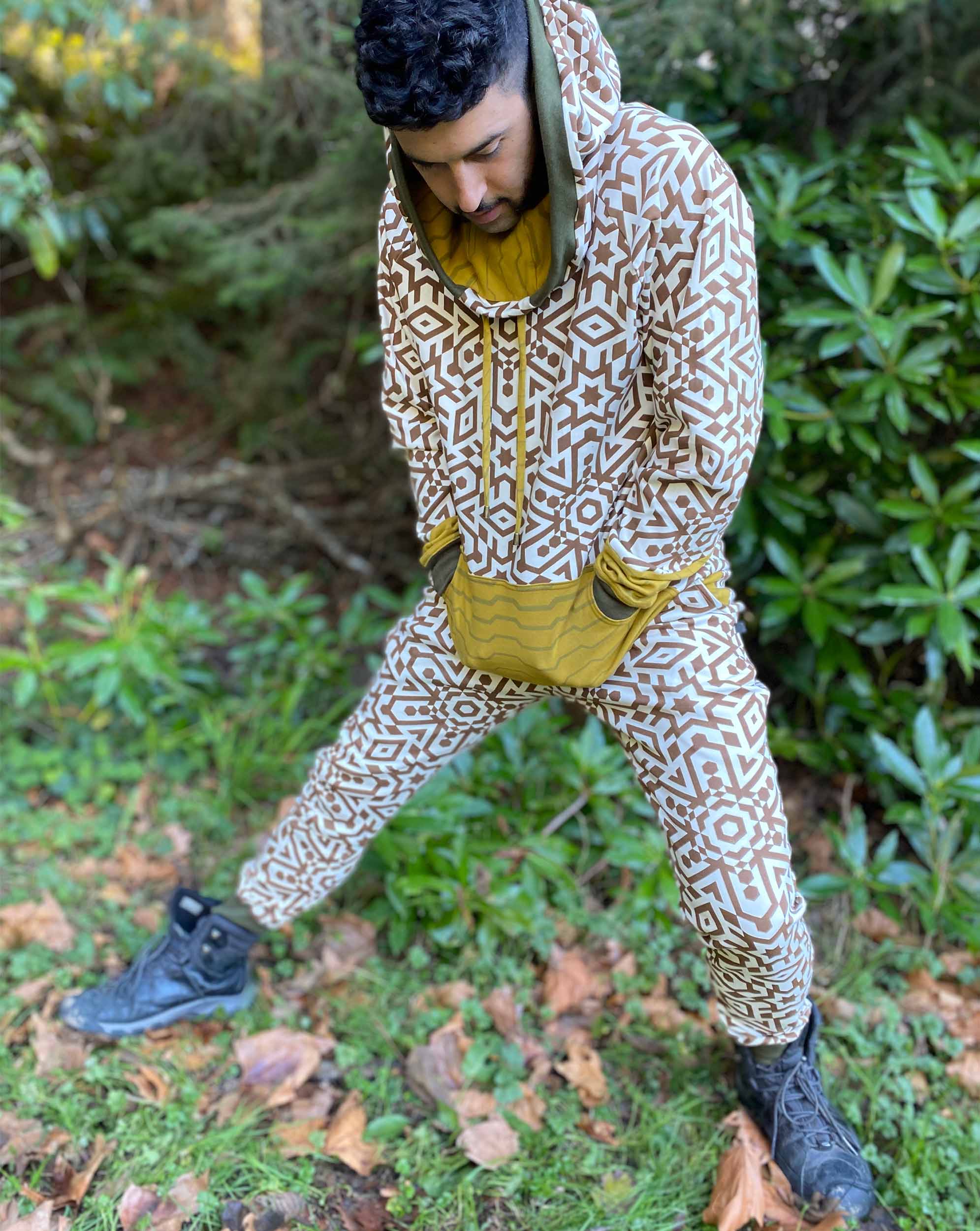 Men's matching two piece sweatsuit, brown geometric print organic fabric, front view, worn on male model.
