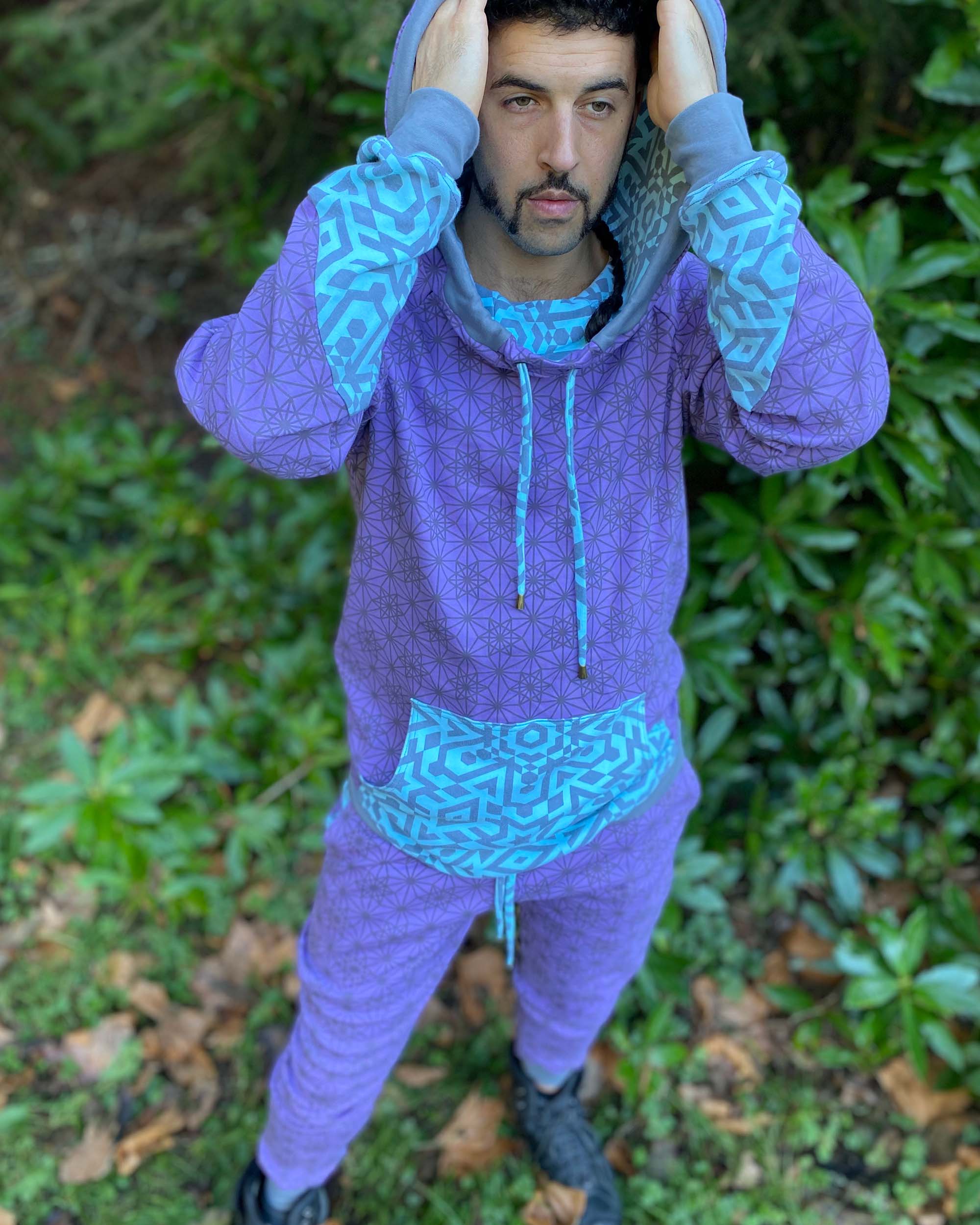 Men's matching two piece sweatsuit, lavender fabric with geometric print, front view on male model.