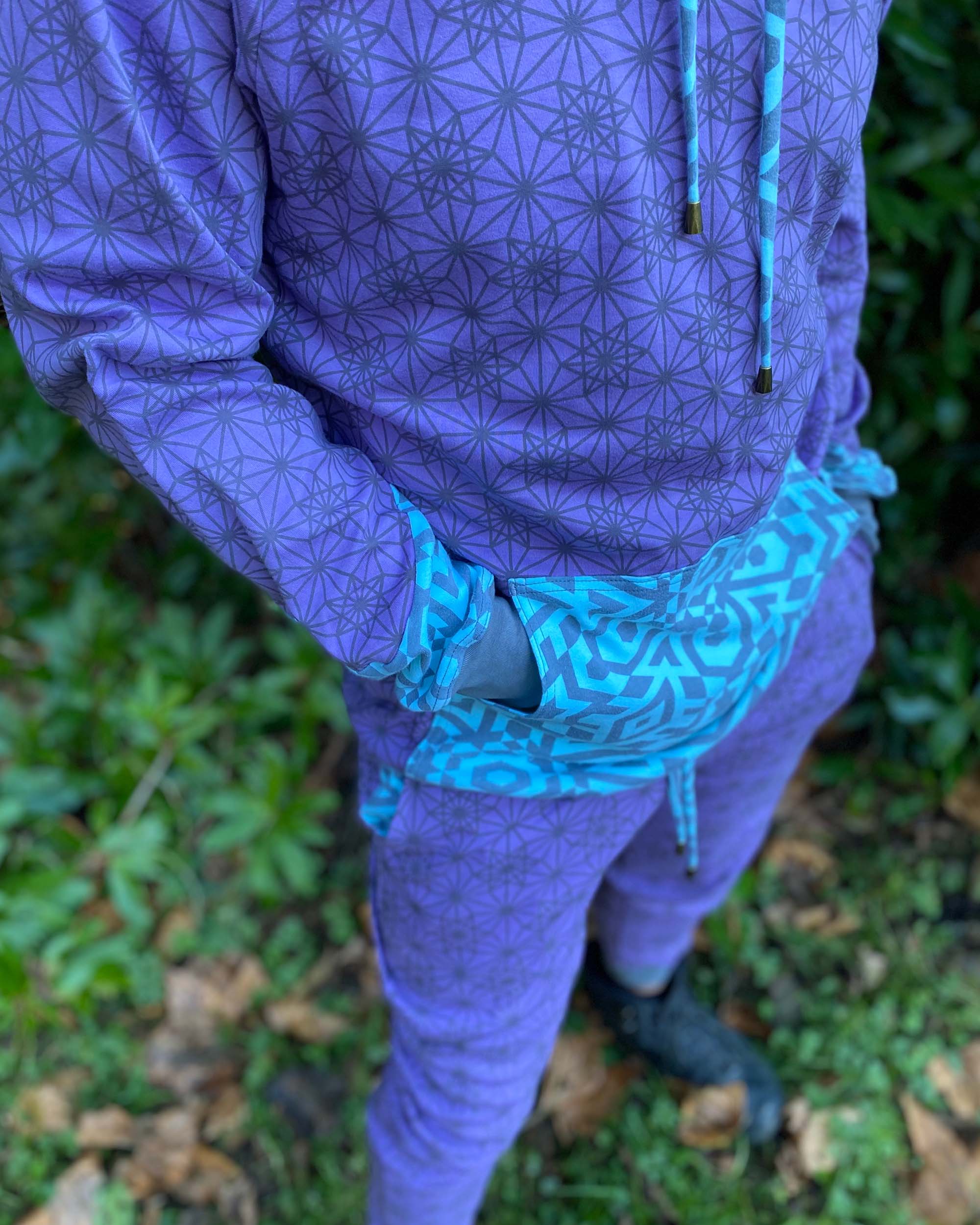 Men's matching two piece sweatsuit, lavender fabric with geometric print, detail view of the pocket.