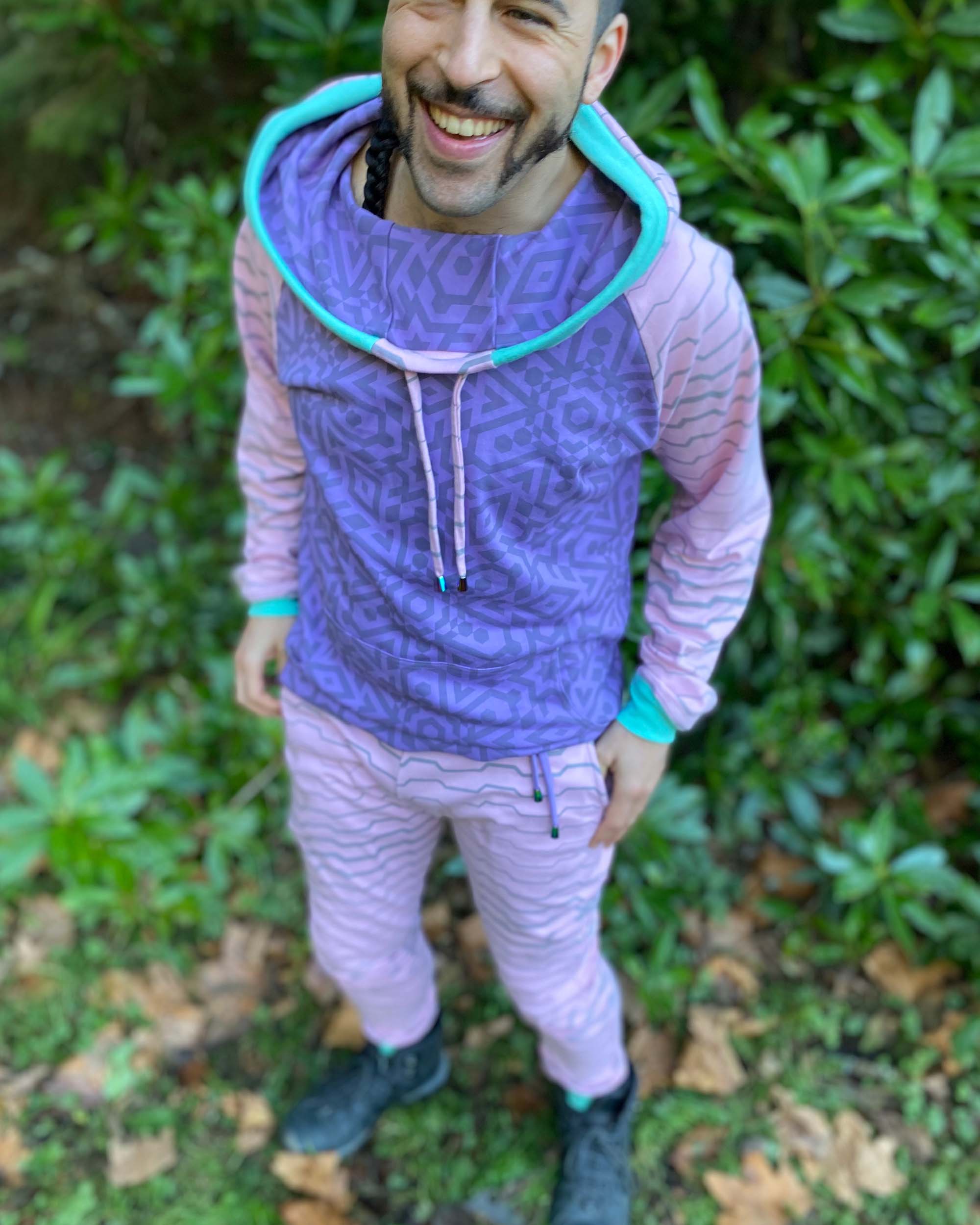 Men's matching two piece sweatsuit, pink and purple fabric, geometric print, front view on model.