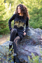 Black hooded dress with gold lotus flower print and pockets. Deep cowl hood. Organic cotton festival wear made in the USA.