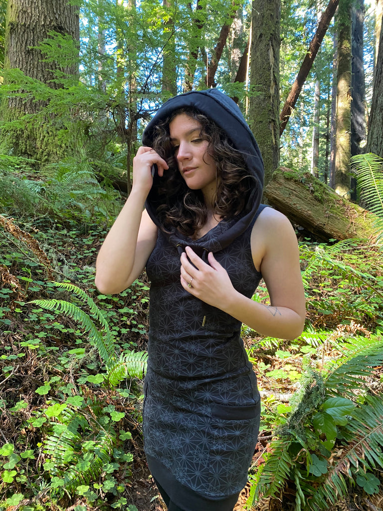 Sleeveless black hoodie dress with pockets. Sacred geometry print. Deep drawstring hood. Made in USA from organic cotton.